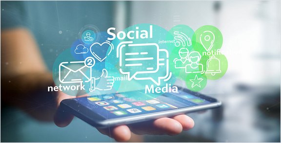 Mobiles Gerät in Händen mit schwebenden Social-Media- und Netzwerksymbolen für Marketingstrategien.