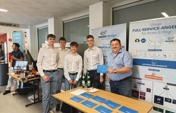 Schülergruppe der HTL Pinkafeld mit einem Vertreter von master design beim Karrieretag 2025 am Unternehmensstand.